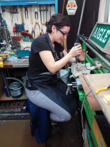 Maricel en el taller de LUCE, perforando fichas
